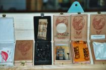 26 geöffnete YAM BOX-Kästchen - hier von links: Jutta Dostert, Christian Sparn, Petra Dutiné, Udo Havekost, Jockel Kroeckel, ...